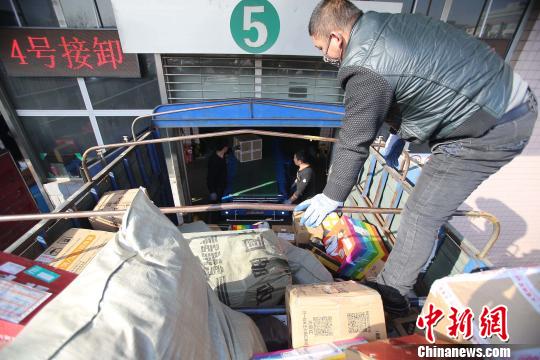 資料圖：工作人員正在給快遞包裹裝車。張?jiān)啤z